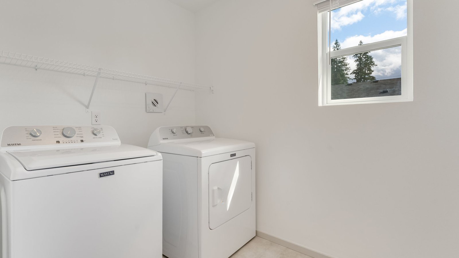 Laundry room with built-in shelves and washer and dryer hookups