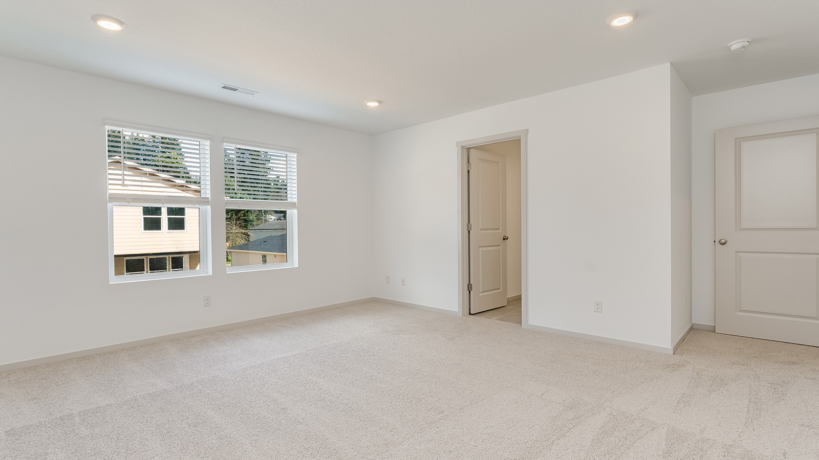 Primary bedroom with wall-to-wall carpet, a walk-in closet and an attached bathroom