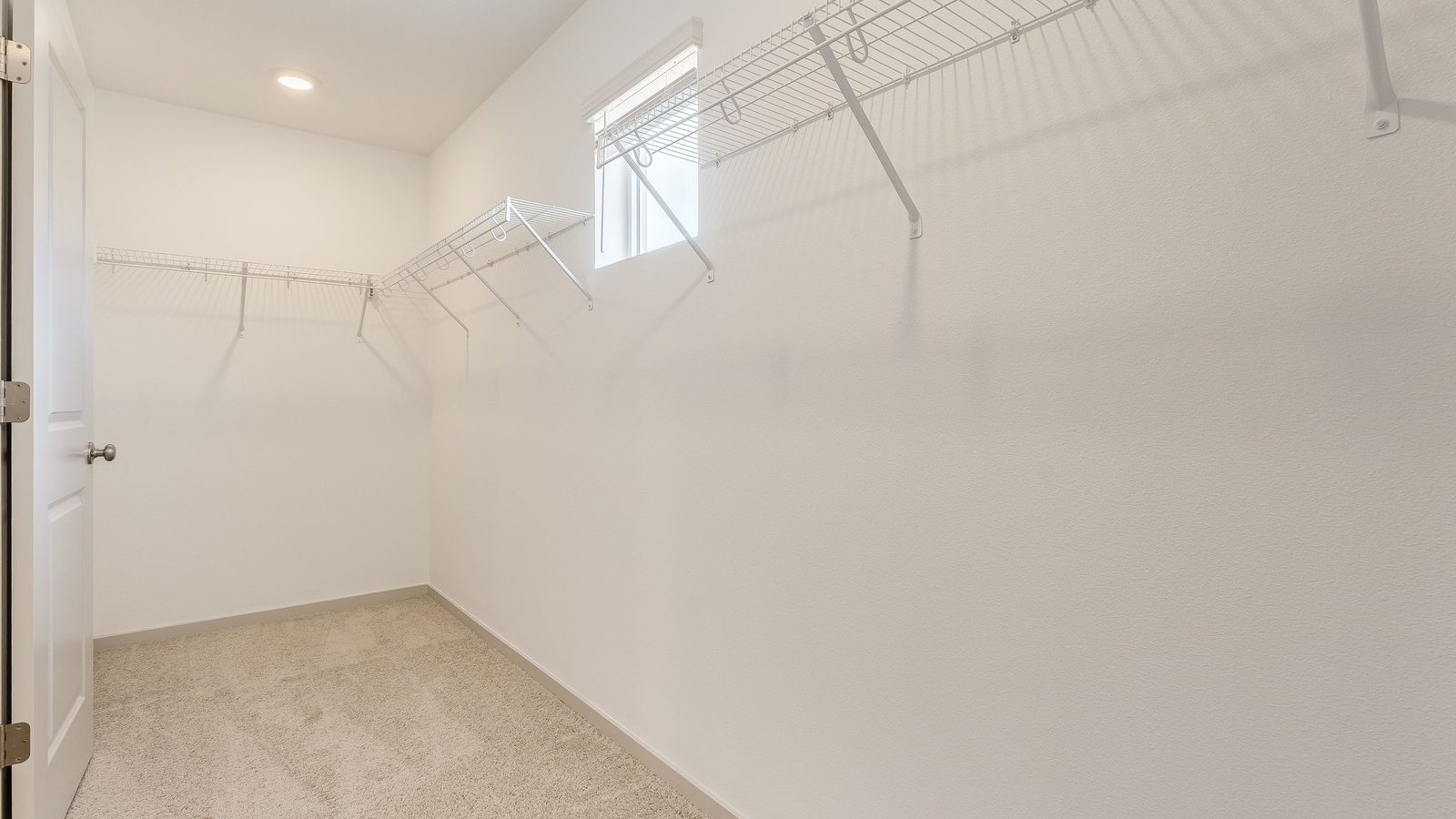 Primary bedroom walk-in closet with wire shelves