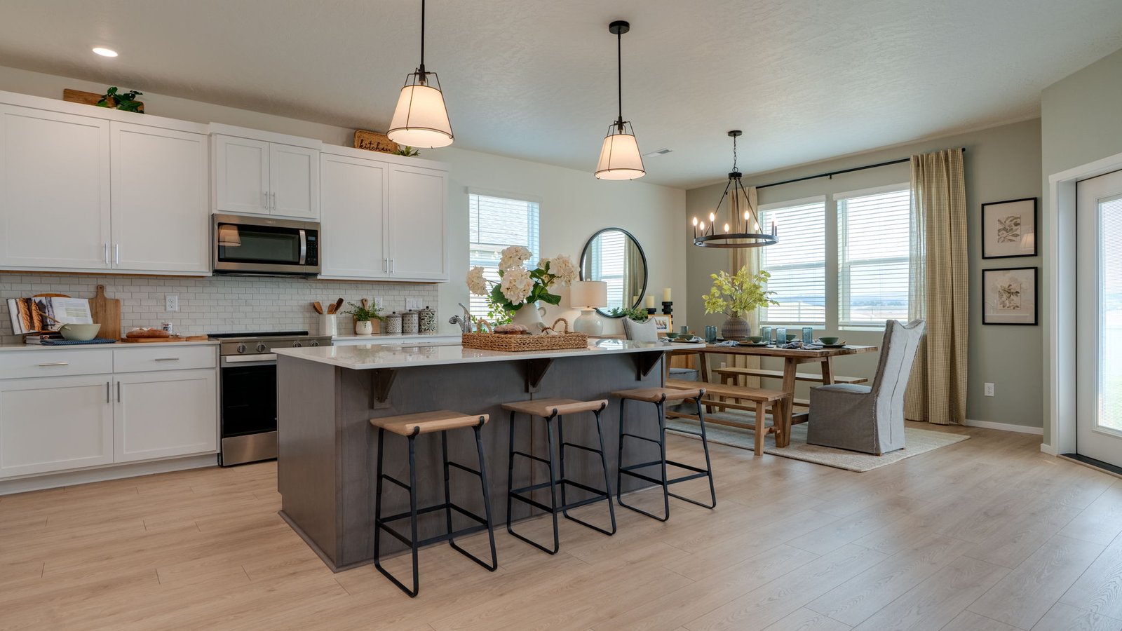 Kitchen with shaker cabinets, quartz counters, stainless steel appliances, pantry, and an island with a breakfast bar