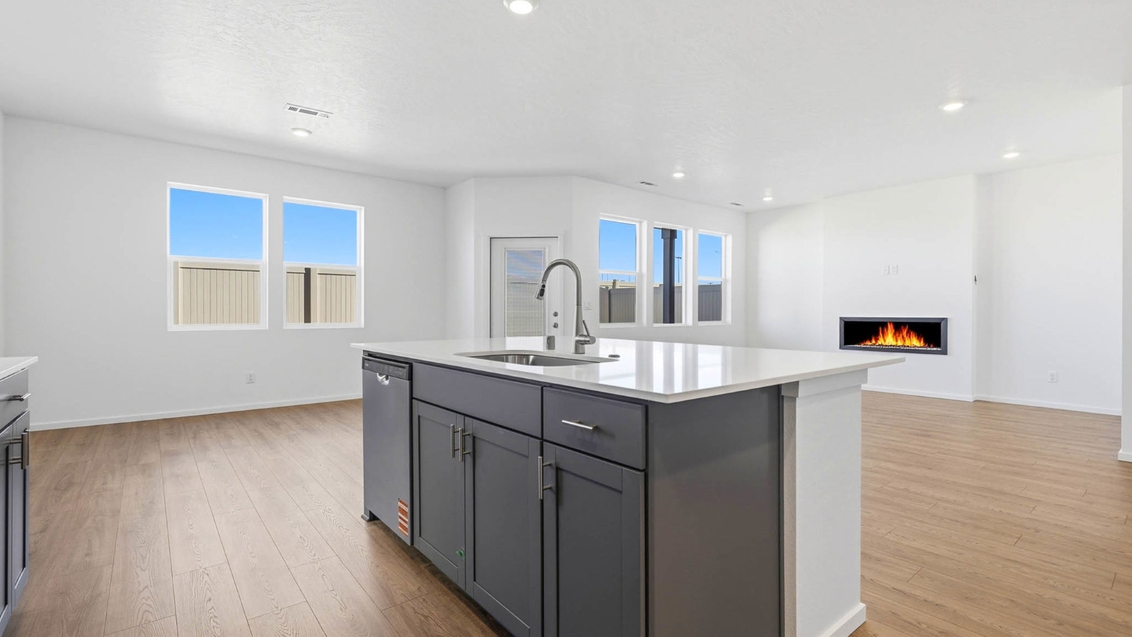 Kitchen with shaker cabinets, quartz counters, stainless steel appliances, pantry, and an island with a breakfast bar