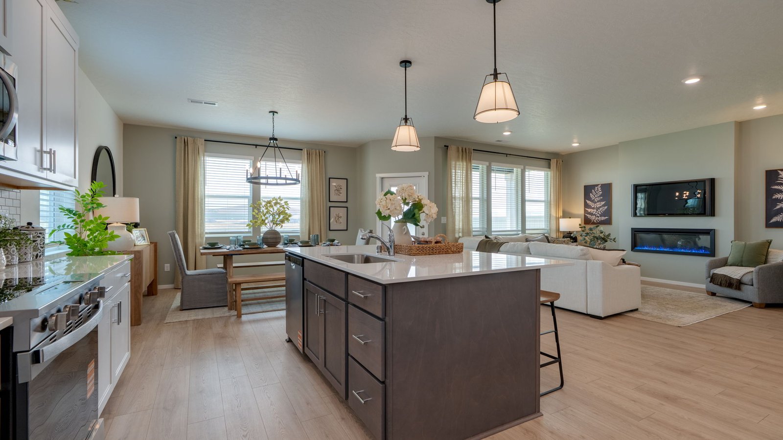 Kitchen with shaker cabinets, quartz counters, stainless steel appliances, pantry, and an island with a breakfast bar