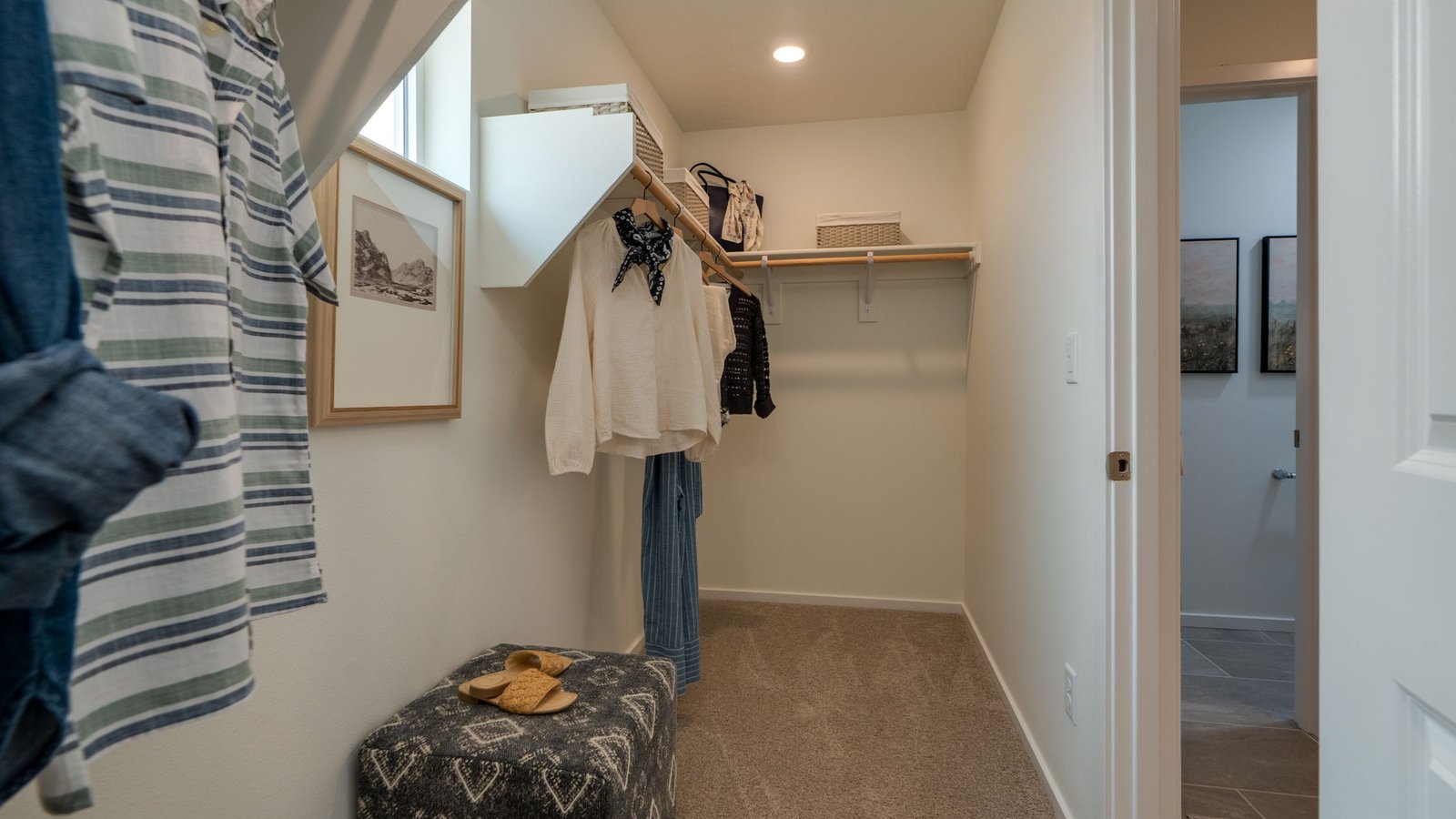 Primary bedroom walk-in closet with built-in shelves