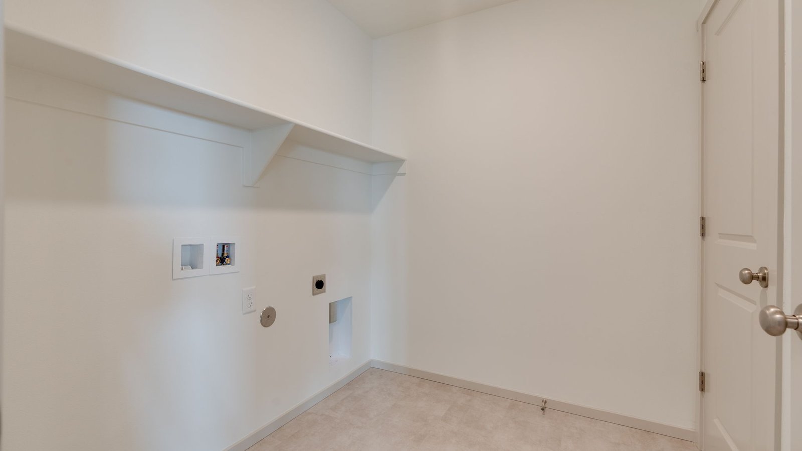 Laundry room with built-in shelves and washer and dryer hookups