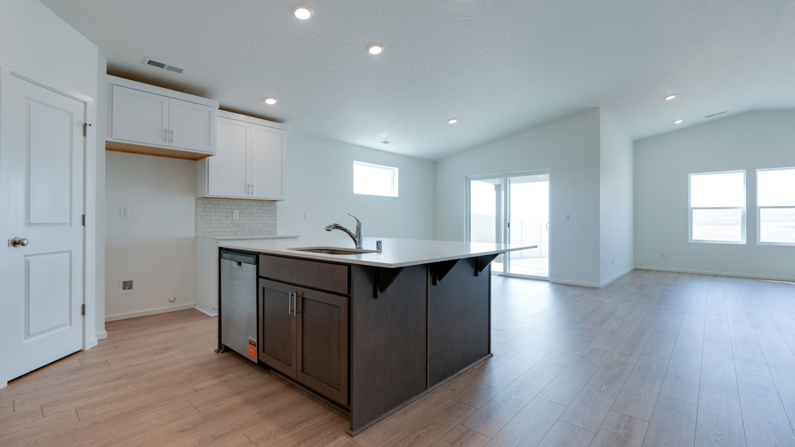 Kitchen with shaker cabinets, quartz counters, stainless steel appliances, pantry, and an island with a breakfast bar