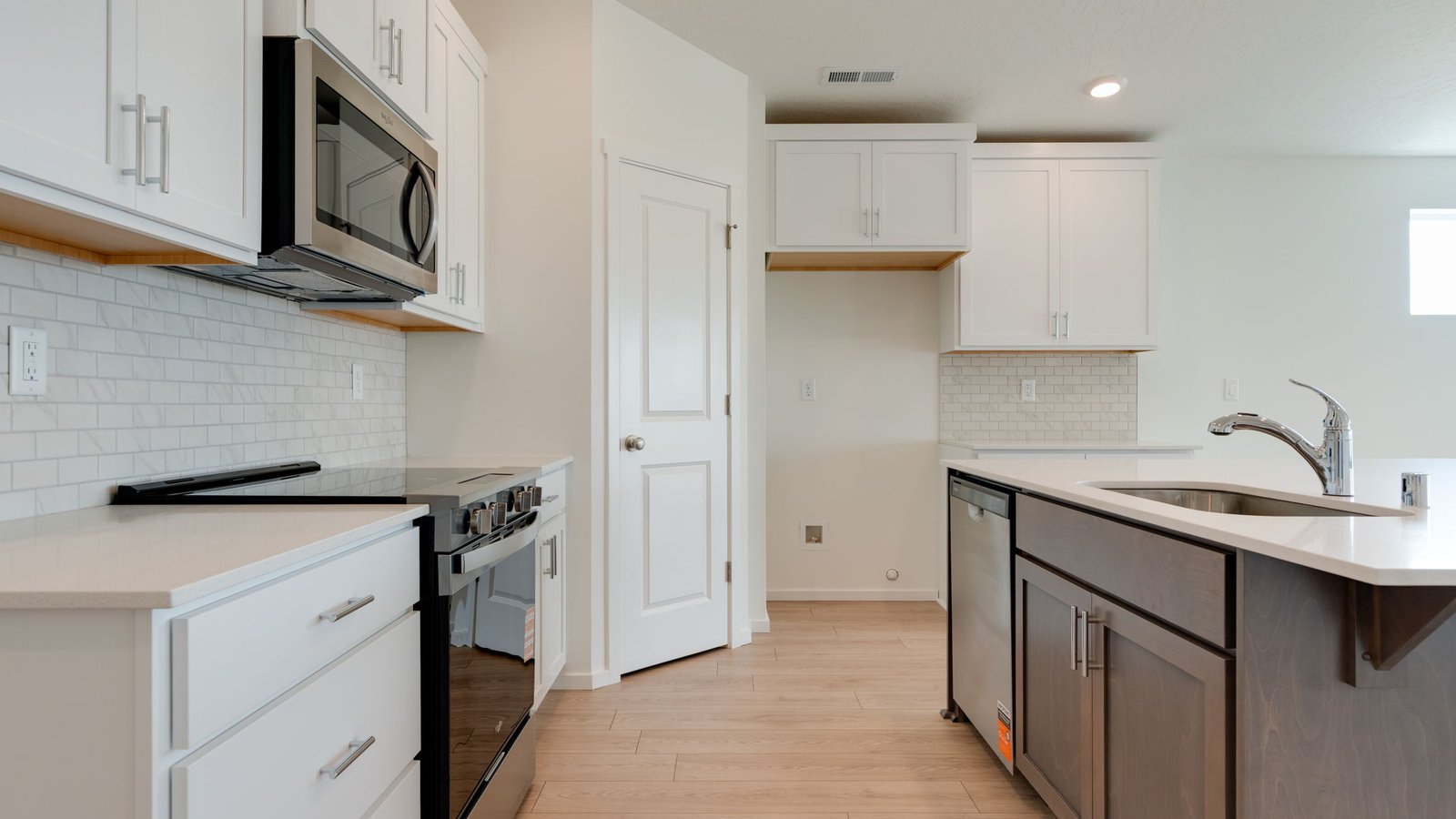 Kitchen with shaker cabinets, quartz counters, stainless steel appliances, pantry, and an island with a breakfast bar