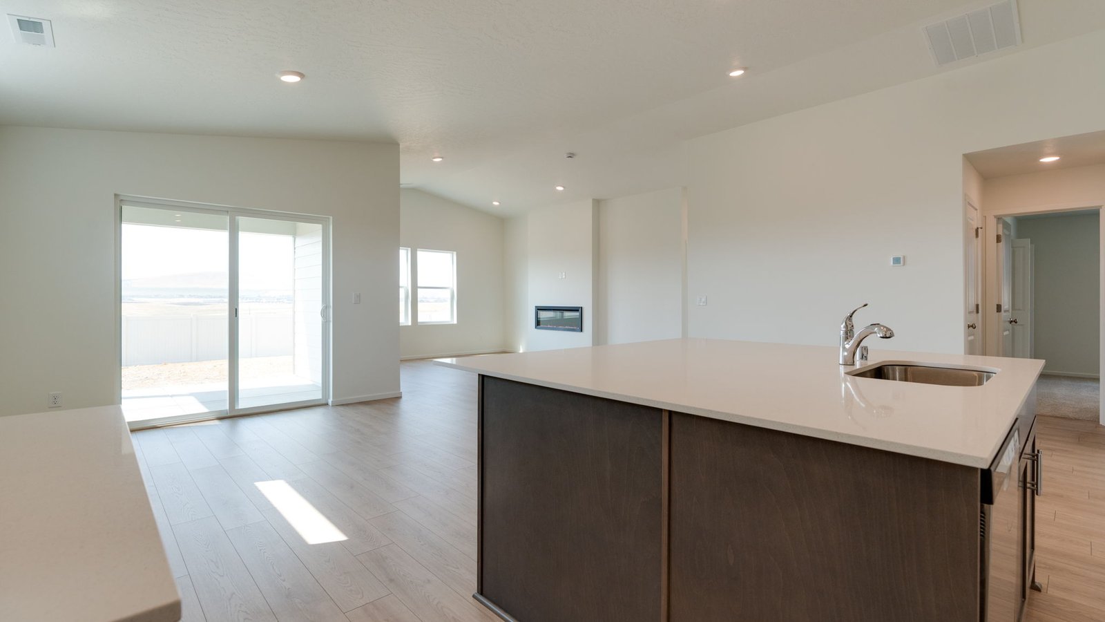 Kitchen with shaker cabinets, quartz counters, stainless steel appliances, pantry, and an island with a breakfast bar