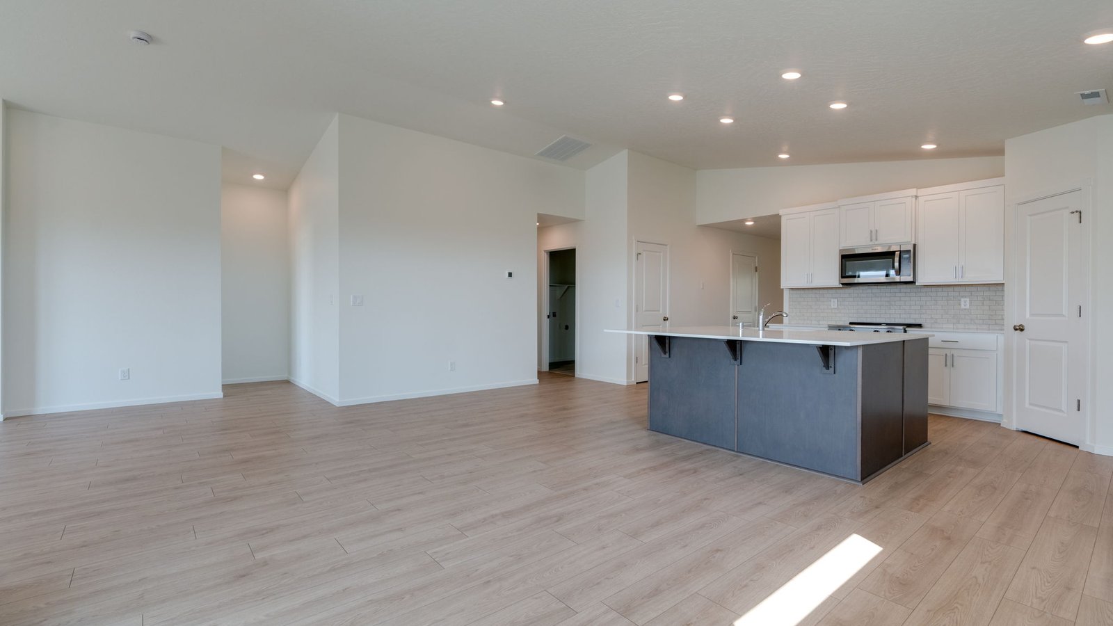 Great room with laminate flooring and an electric fireplace and vaulted ceilings