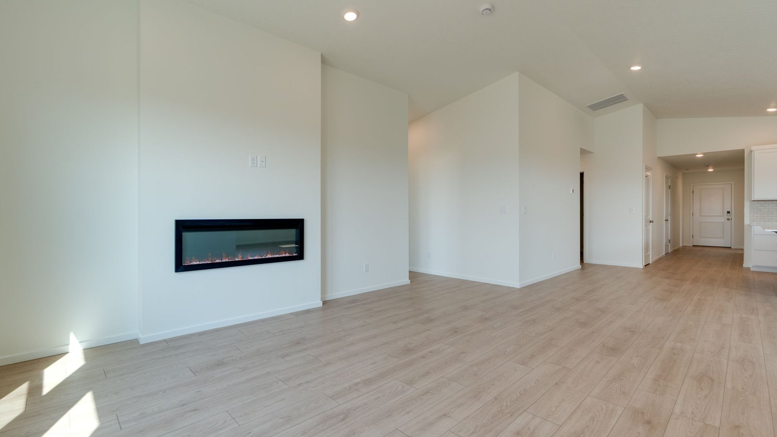 Great room with laminate flooring and an electric fireplace and vaulted ceilings