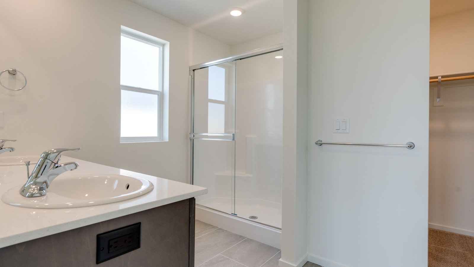Primary bathroom with quartz counters and a walk-in shower