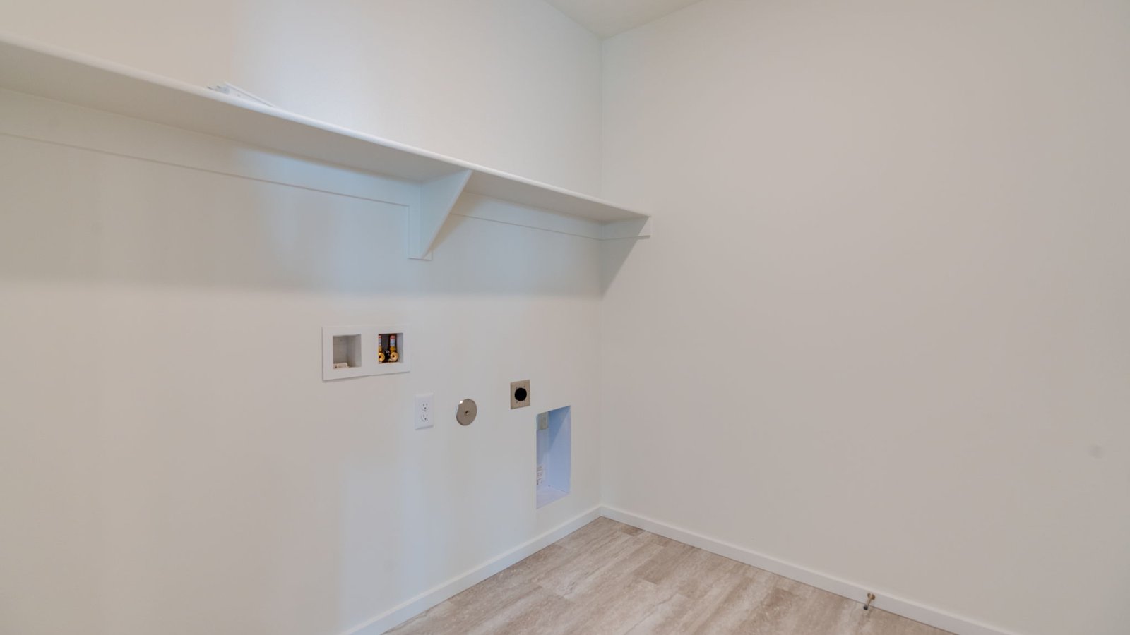 Laundry room with built-in shelves and washer and dryer hookups