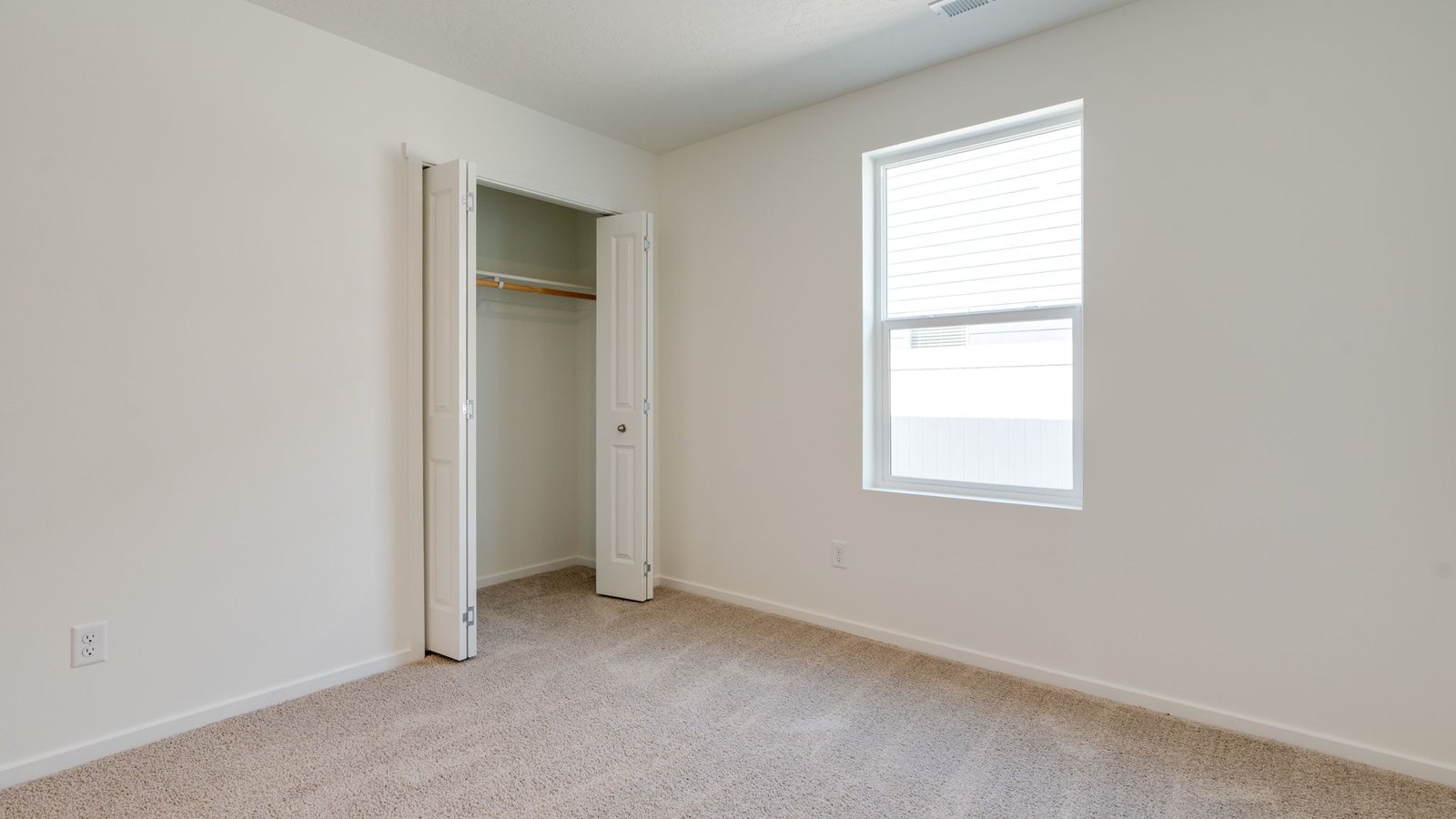 Bedroom with wall-to-wall carpet and a closet