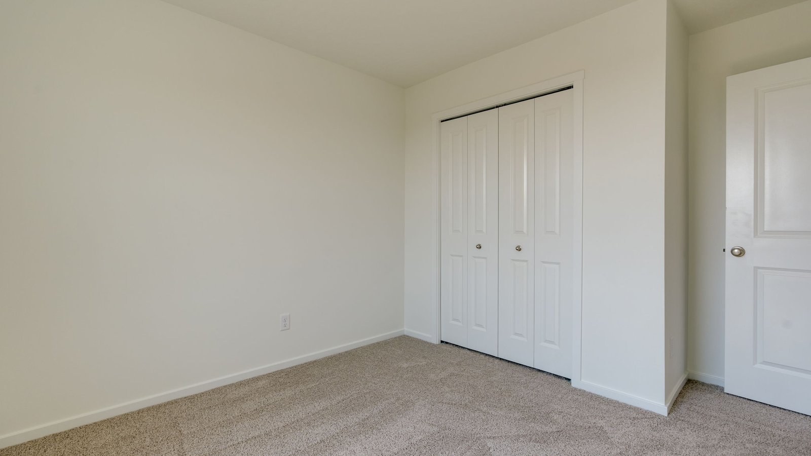 Bedroom with wall-to-wall carpet and a closet