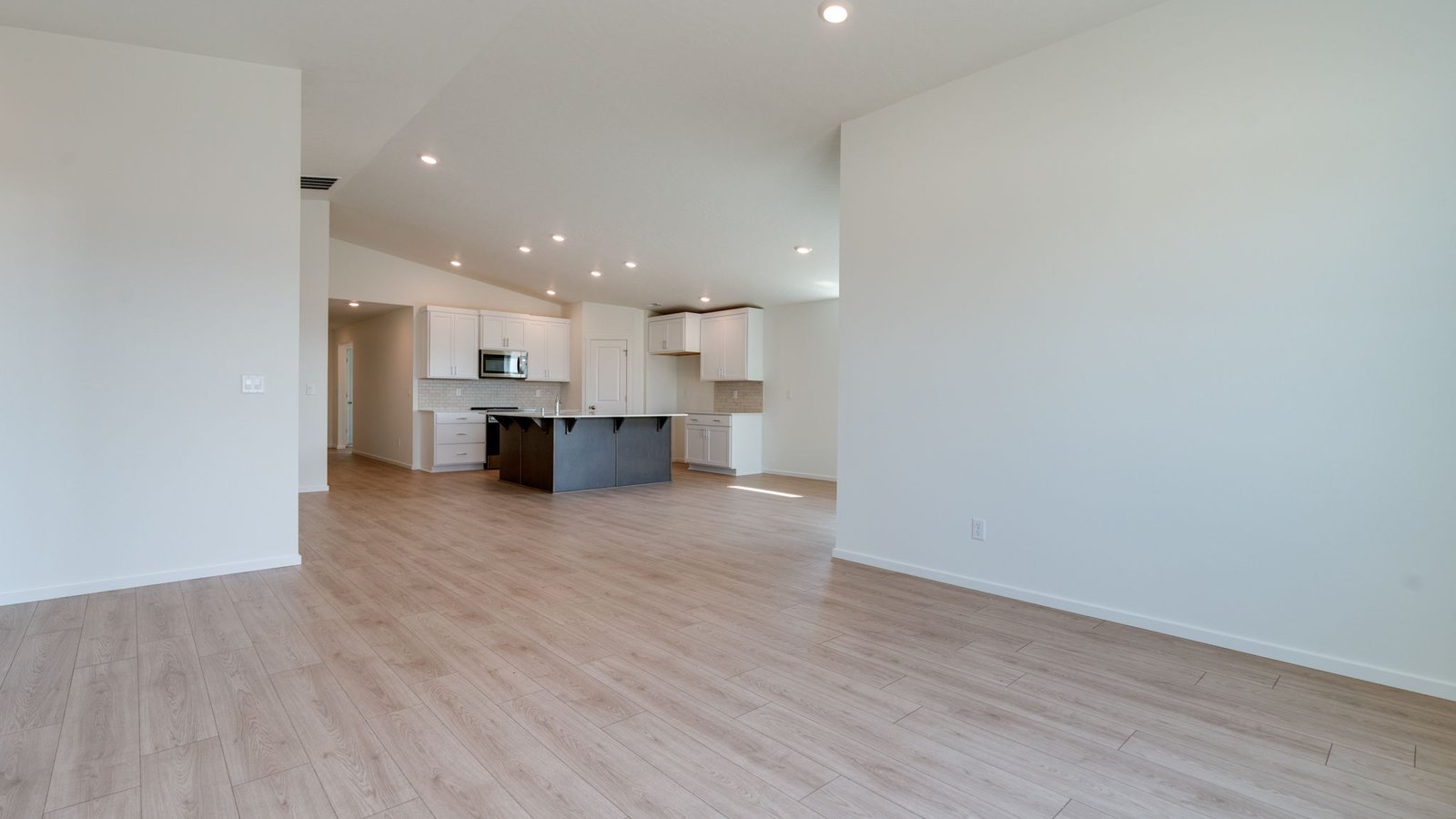 Great room with laminate flooring and an electric fireplace and vaulted ceilings
