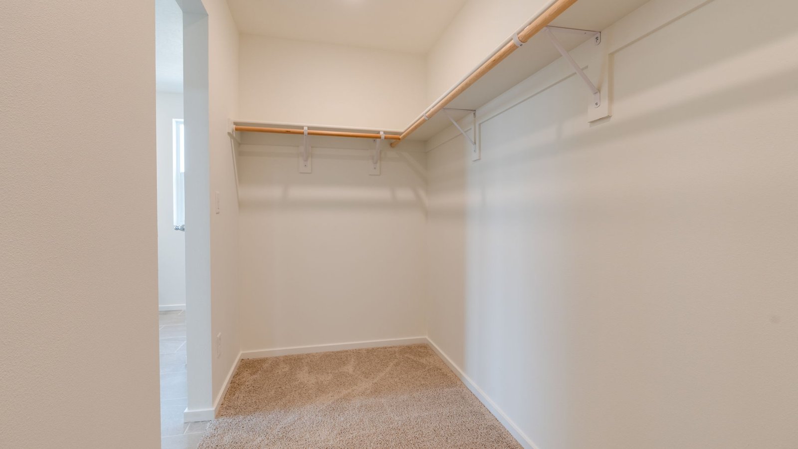 Primary bedroom walk-in closet with built-in shelves