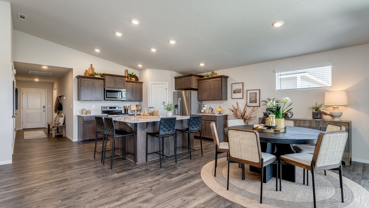 Kitchen with shaker cabinets, quartz counters, stainless steel appliances, pantry, and an island with a breakfast bar