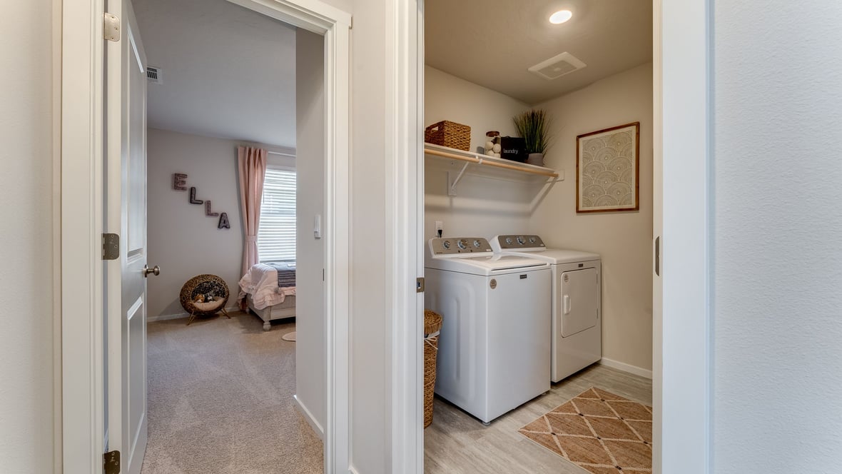 Laundry room with built-in shelves and washer and dryer hookups