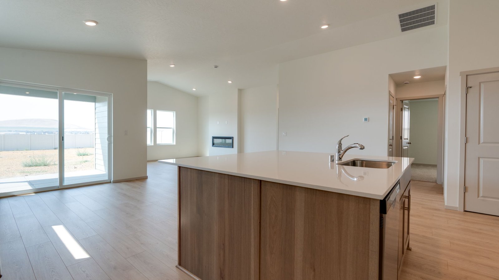 Kitchen with shaker cabinets, quartz counters, stainless steel appliances, pantry, and an island with a breakfast bar