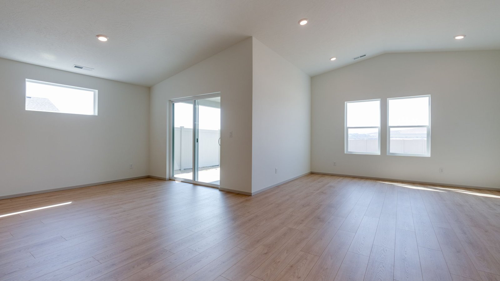 Great room with laminate flooring and an electric fireplace and vaulted ceilings