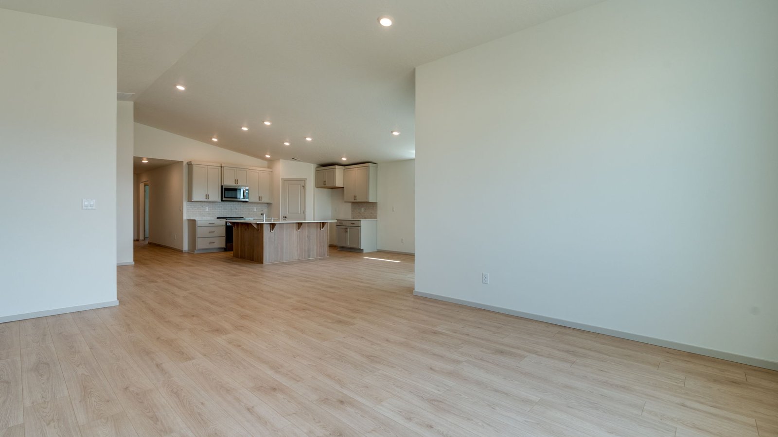 Great room with laminate flooring and an electric fireplace and vaulted ceilings