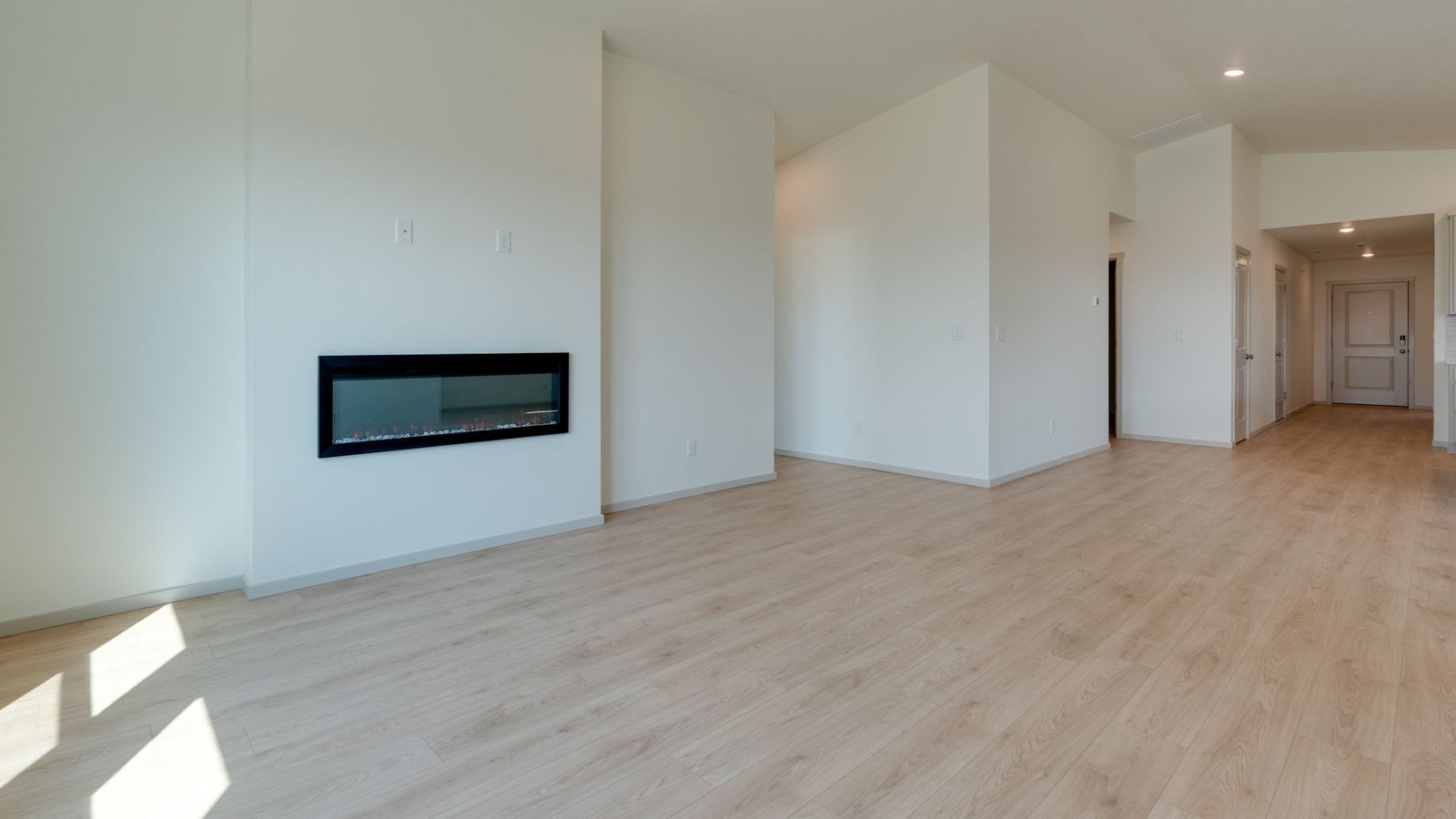 Great room with laminate flooring and an electric fireplace and vaulted ceilings