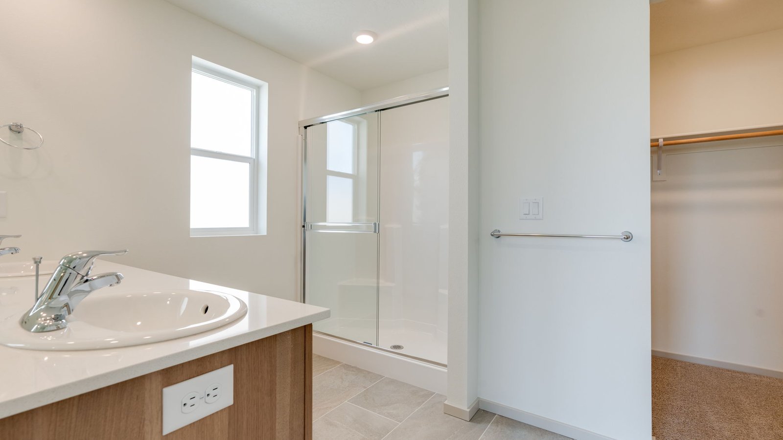 Primary bathroom with quartz counters and a walk-in shower