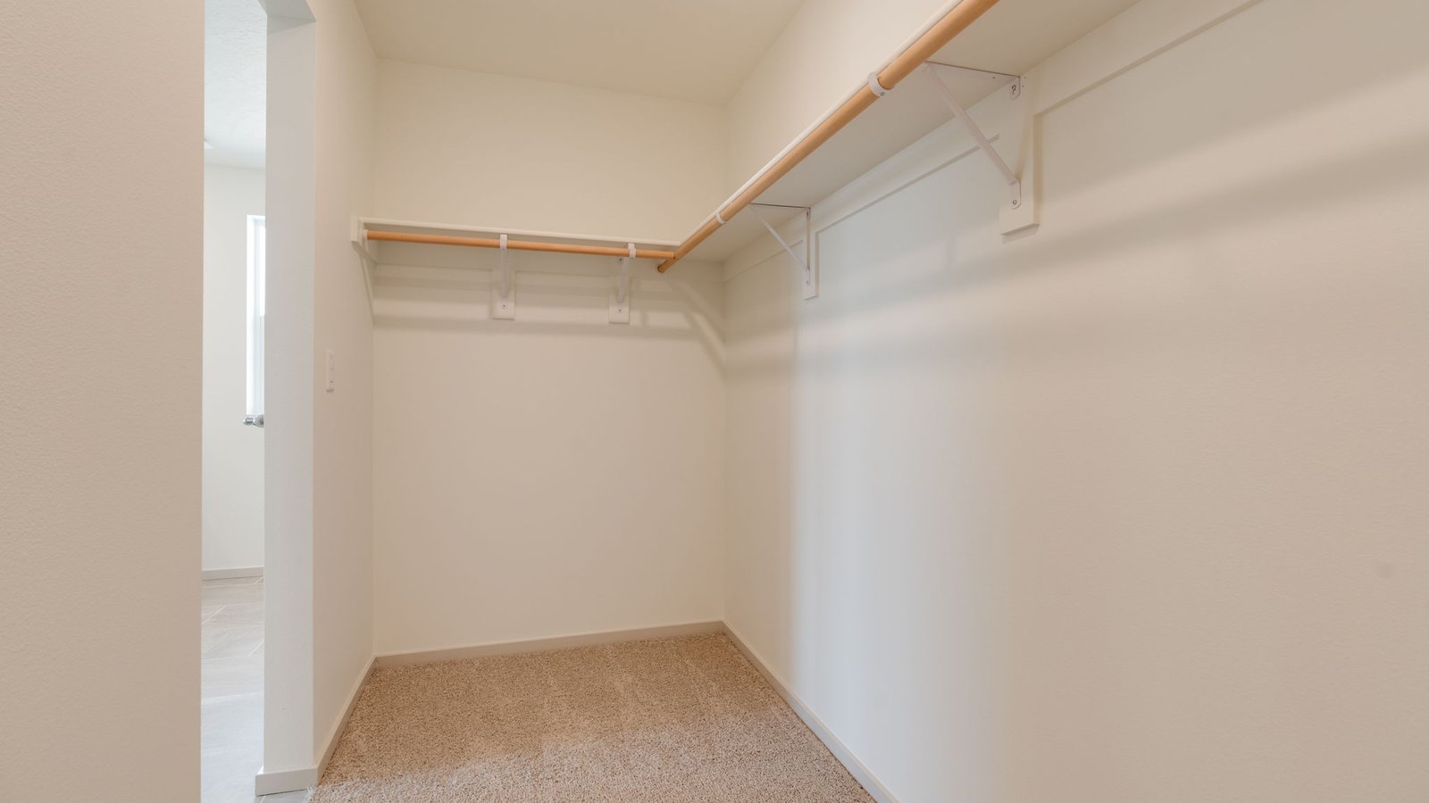 Primary bedroom walk-in closet with built-in shelves