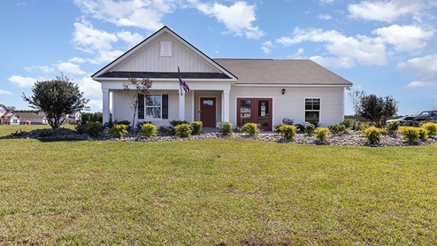 Single-story home with white siding and covered porch and two-car garage sales model