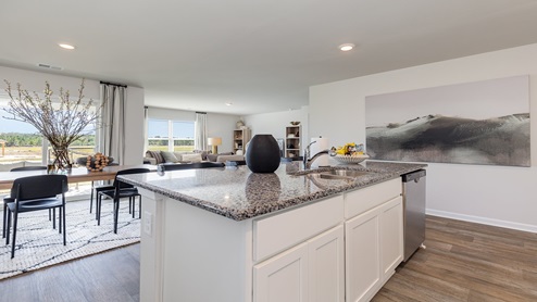 Kitchen peninsula with white cabinets and stainless steel appliances