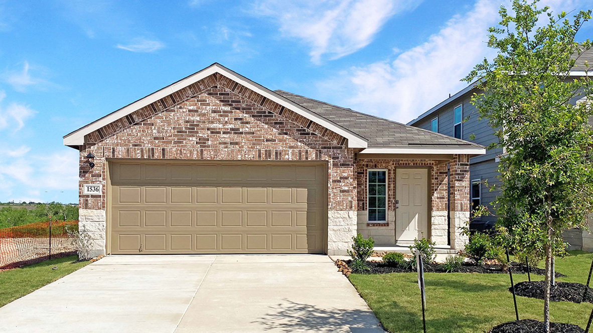 One story home with covered porch, brick and stone front exterior and two car garage.
