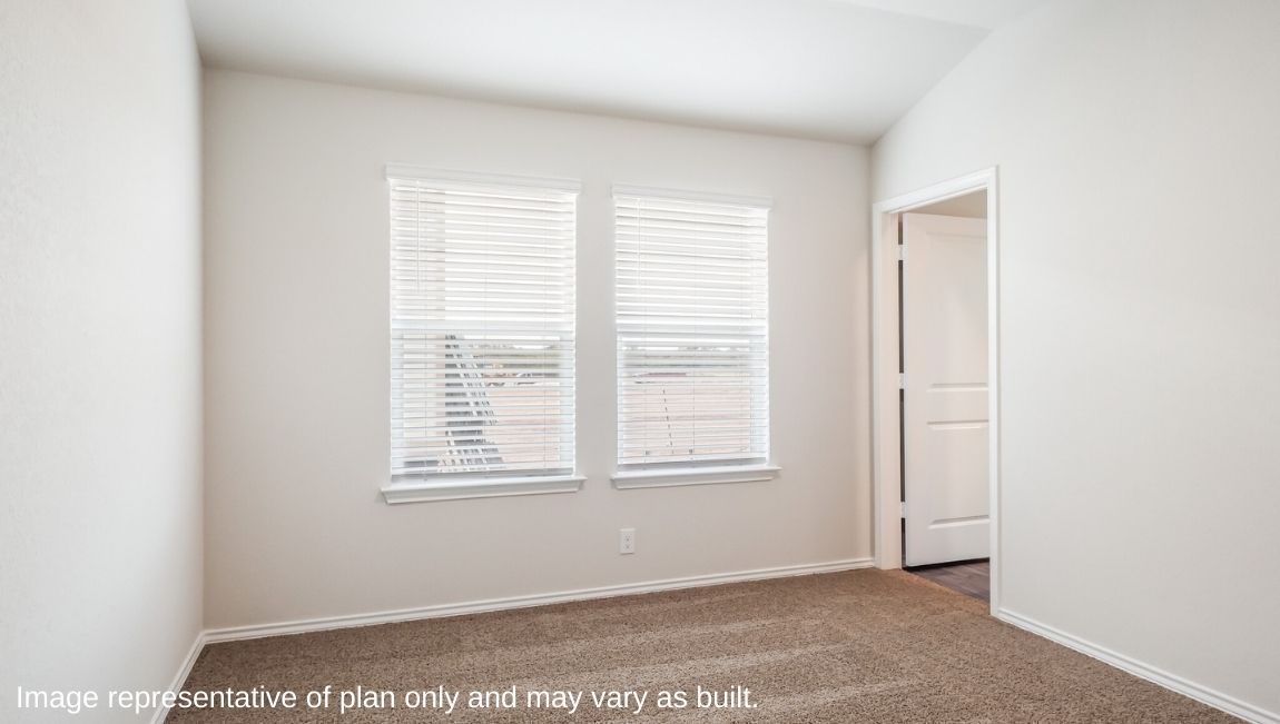 Spacious primary bedroom with carpet and windows.
