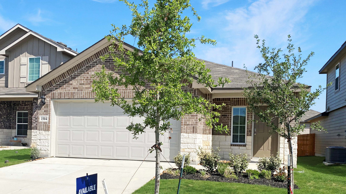 One story home with covered porch, brick and stone front exterior and two car garage.