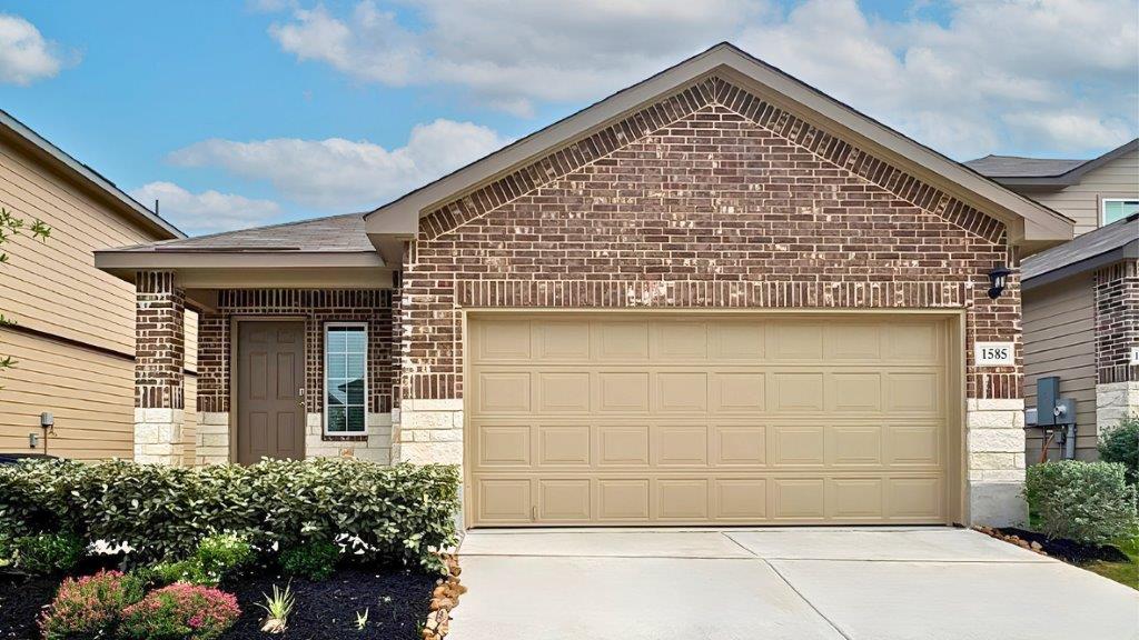 One story home with covered porch, brick and stone front exterior and two car garage.