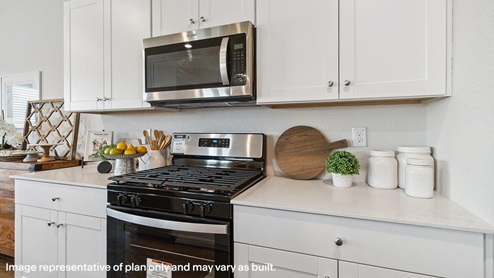 Open-concept kitchen with spacious corner pantry and plenty of cabinet space.