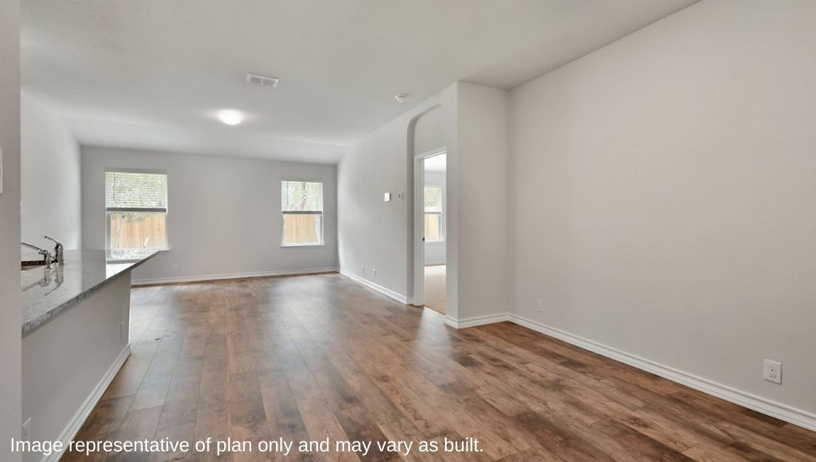 open concept dining area leading to living room with hard surface flooring throughout