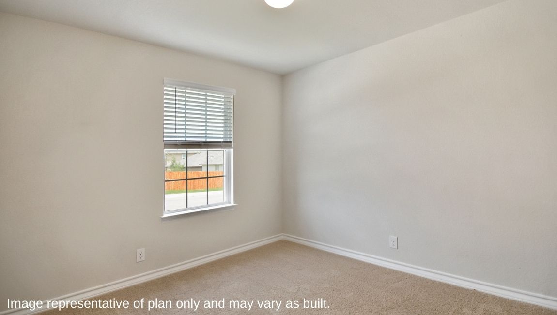 Secondary bedroom with carpet and window.