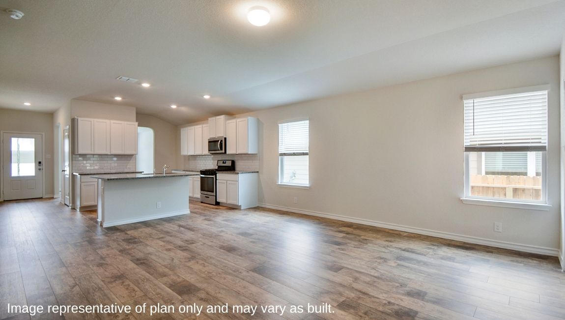 Kitchen with stainless steel appliances and spacious kitchen island overlooking living room.