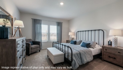 DR Horton Von Ormy Preserve at Medina the florence floor plan 1858 square feet main bedroom suite with carpet flooring king sized bed dresser and doorway leading to ensuite bathroom