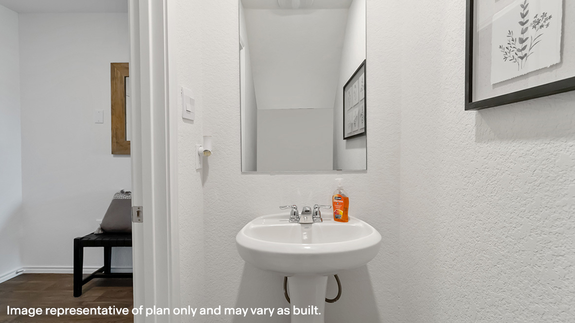 Half bath with door opening to hallway, pedestal sink, mirror visible with shiny faucet in Preserve at Medina