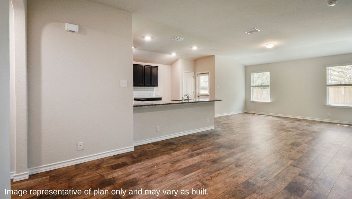 Open concept kitchen area connecting to living and dining space.