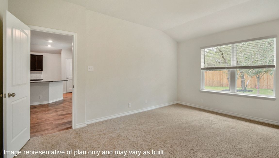 Primary bedroom with large windows and neutral walls off the kitchen.