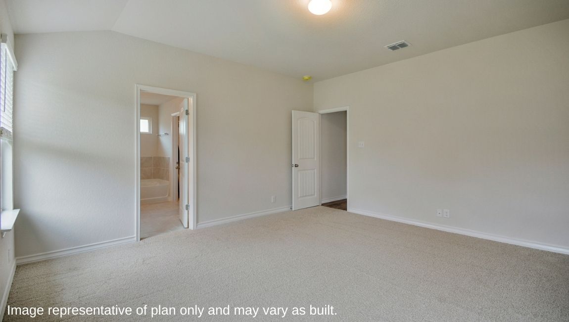 Primary bedroom with carpet, natural lighting, and a bathroom attached.