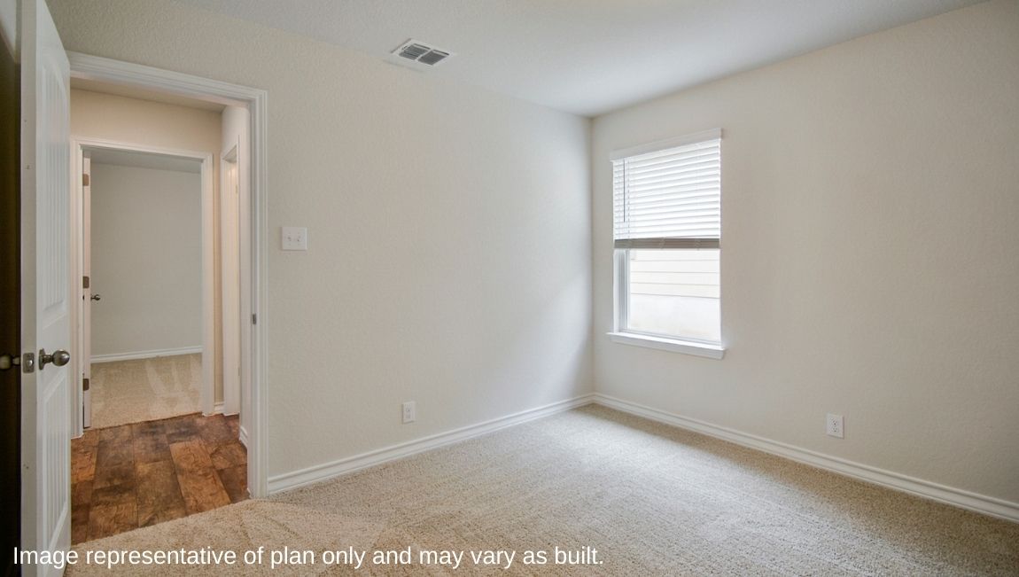 Carpeted bedroom with a window and a bathroom attached.