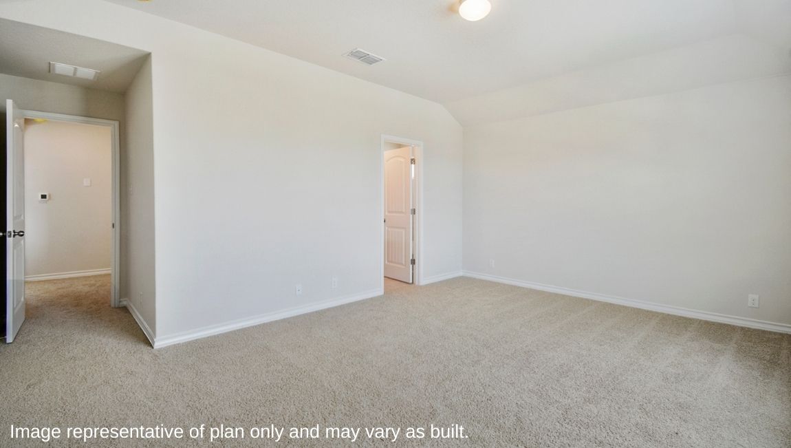 Primary bedroom with carpet, natural lighting, and a bathroom attached.