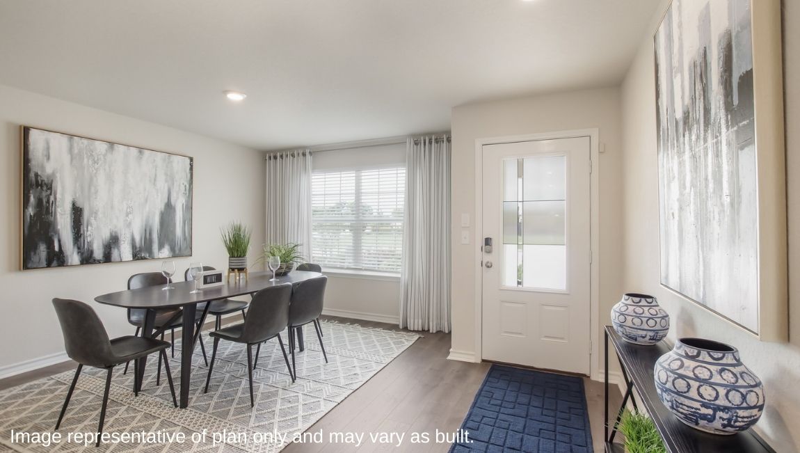 Dining area with table, chairs, and natural lighting off the entry.