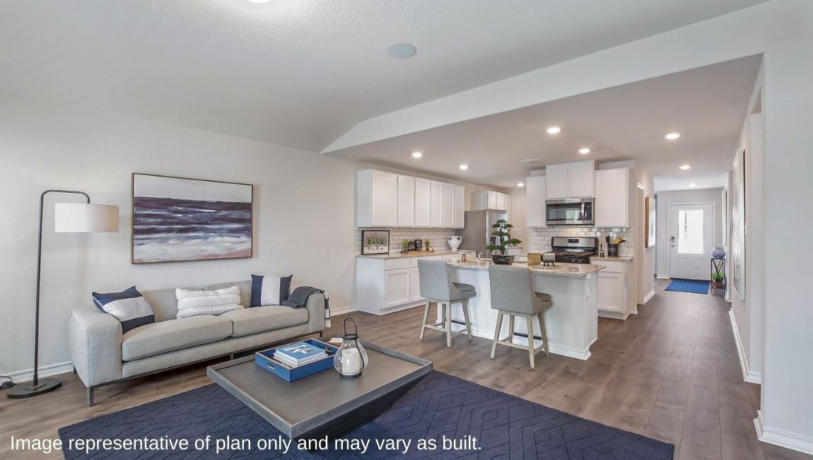 Main living area with clean flooring and natural light connecting to kitchen.