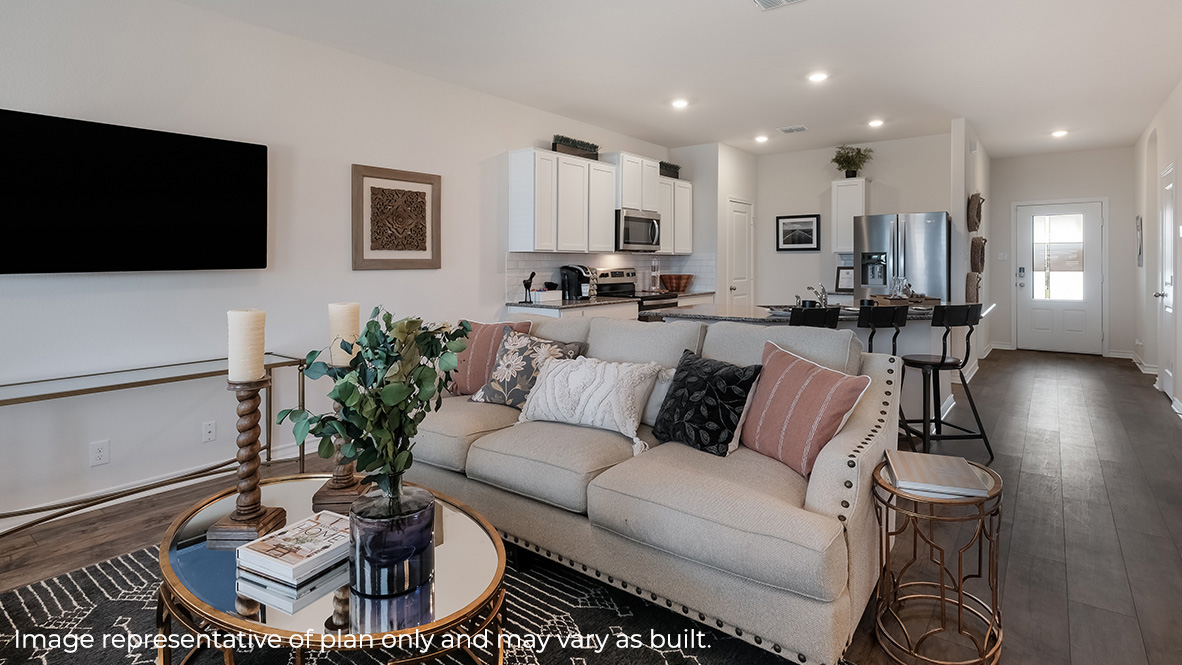 Main living area with clean flooring and natural light connecting to kitchen.