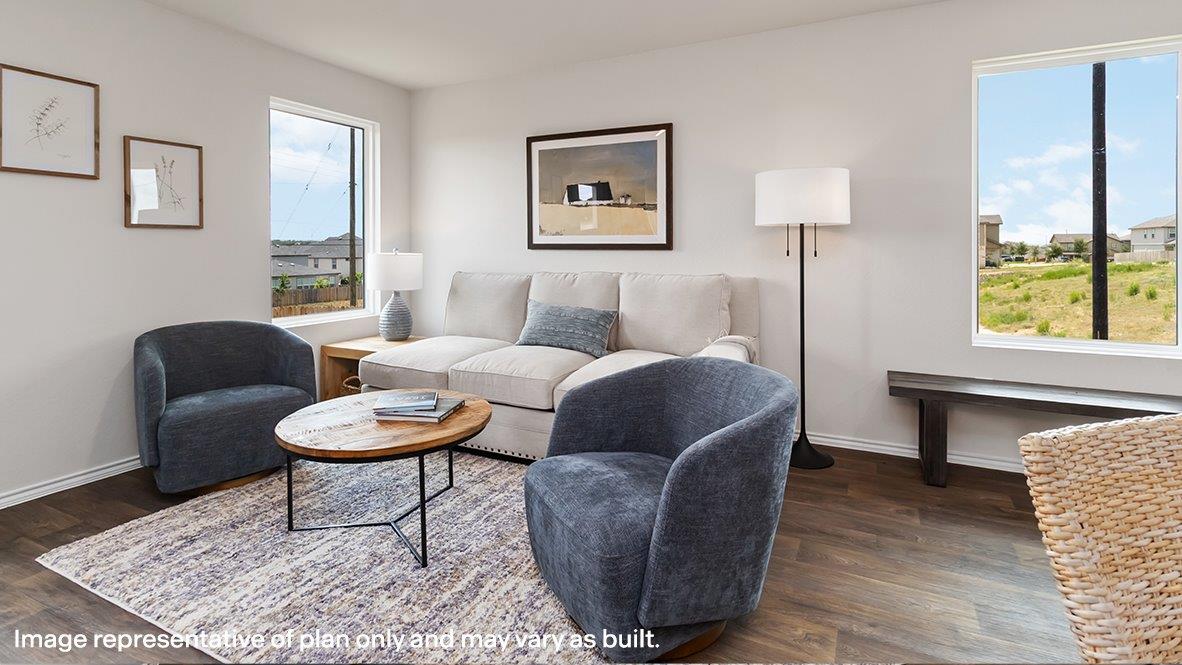 Living room with brown flooring and white walls.