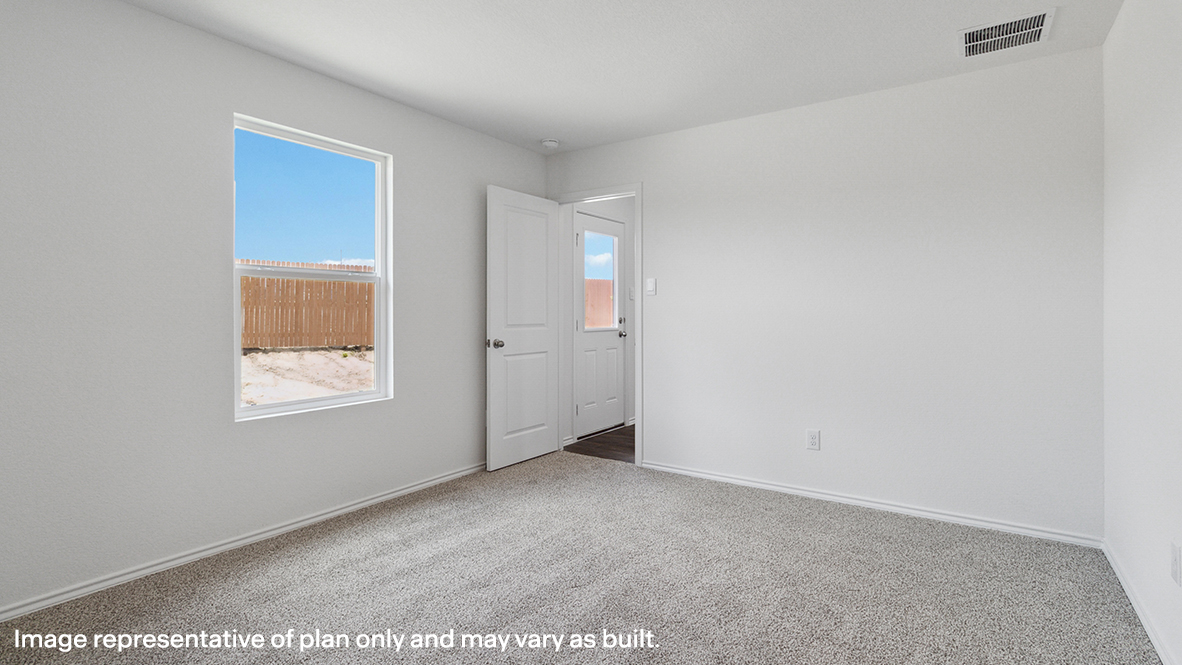 Primary bedroom with carpeted floors and a window.