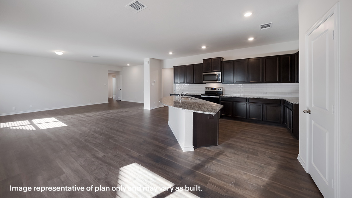 Spacious kitchen with oversized kitchen island and hard surface flooring.